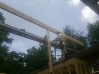 Carpenter setting a ridge beam over a new addition frame — Ice Dam Removal by Roofing Brothers in Kanosh
