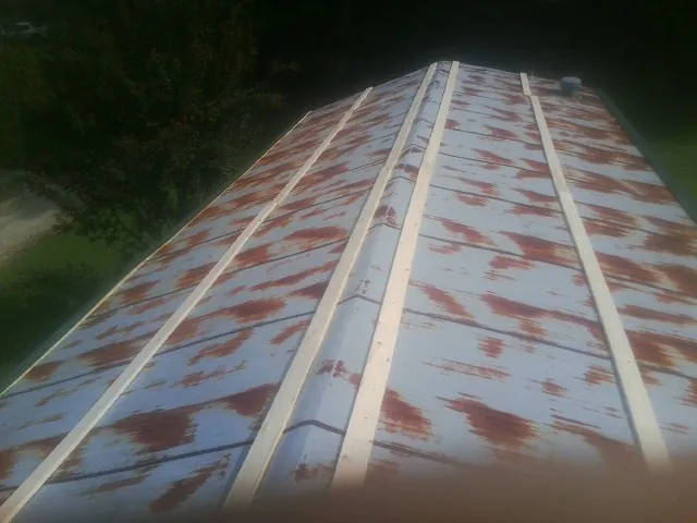 Rusted metal roof panels with new wood purlins before replacement — Storm Damage Roof Repair in Kanosh by Roofing Brothers